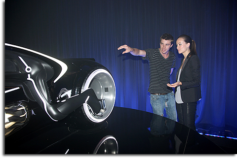 Garrett Hedlund and Olivia Wilde examine a lightcycle